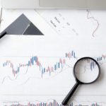 Stock Market - Magnifying Glass on Top of Document