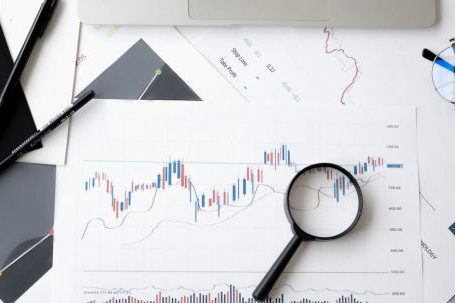 Stock Market - Magnifying Glass on Top of Document