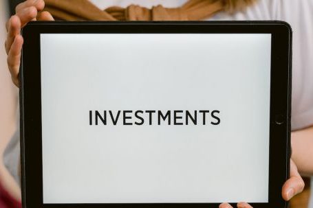 Investments - Close-Up Shot of a Person Holding a Tablet