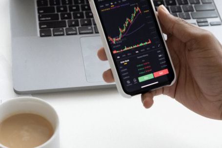 Stock Market - Person holding Mug and Mobile Phone