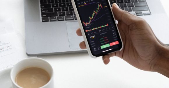 Stock Market - Person holding Mug and Mobile Phone